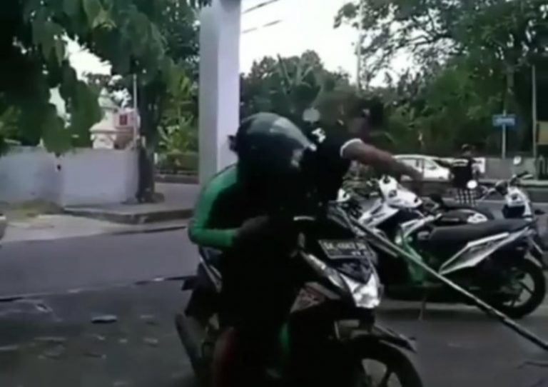 Nongkrong di tempat yang sedang digelar acara adat kepala driver ojol ini dipukul pecalang