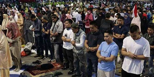 Massa pendemo sholat di depan kantor Bawaslu